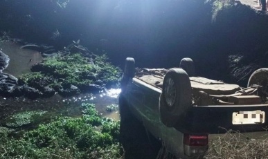 Casal é resgatado de veículo que capotou dentro de córrego após sair da pista